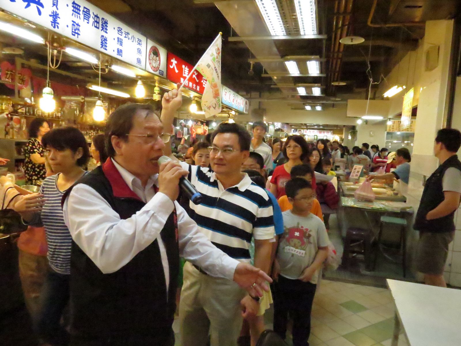由泰山市場自治會總幹事陳祖勇及處長謝俊隆，一起帶小朋友巡禮市場。