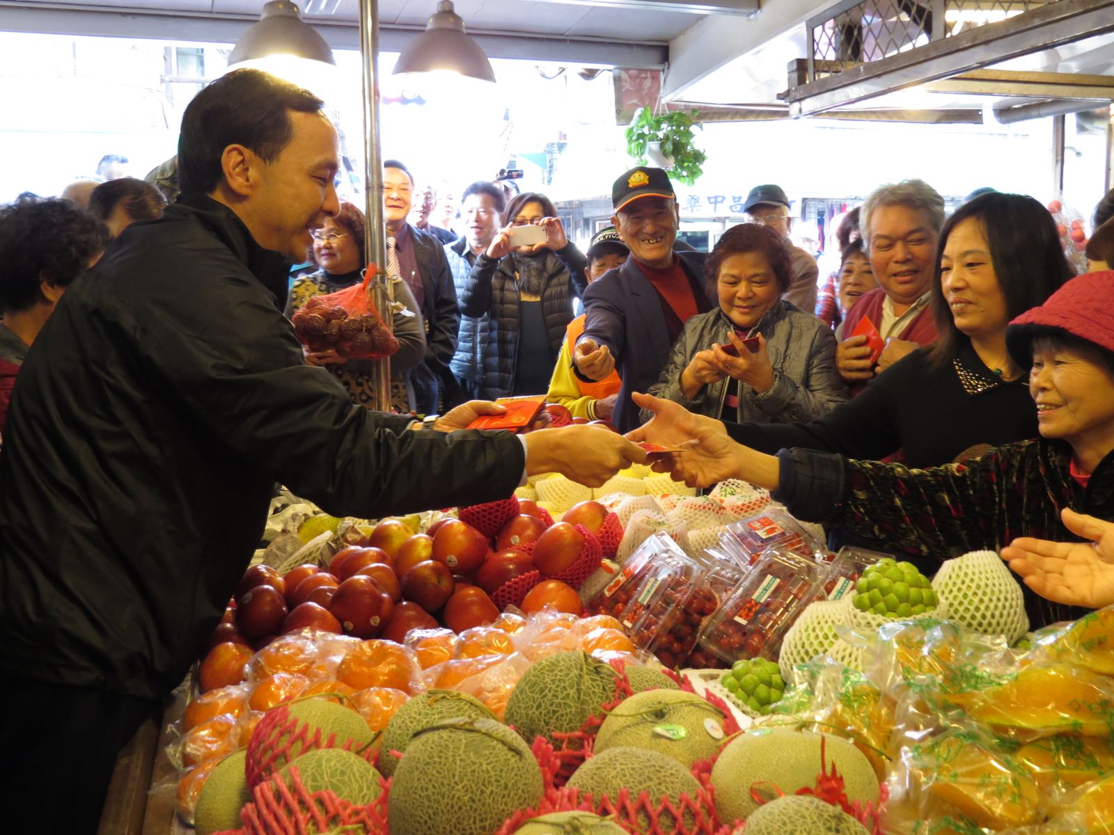 新北市長朱立倫上午到金山第一市場拜年發紅包，許多攤商爭相與市長握手，拿到紅包時都感到非常開心。