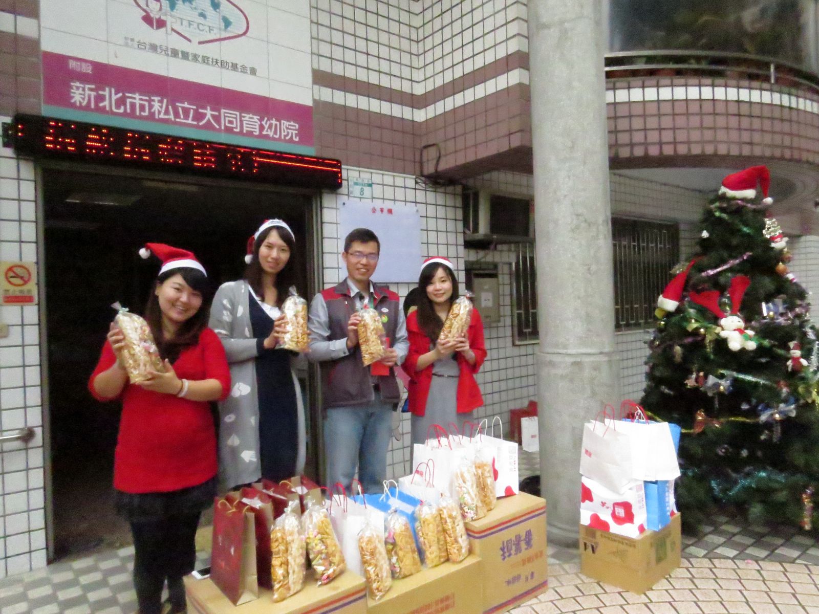 市場處市場經營科長陳即如(左二)代表市場贈送聖誕禮物與大同育幼院。
