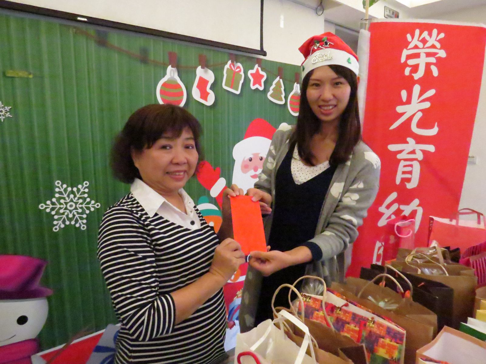 市場處市場經營科長陳即如(右1)代表市場贈送聖誕禮物與大同育幼院。   
