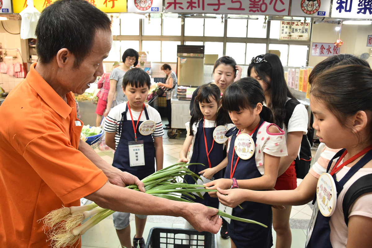 圖說4：泰山市場攤商教導認識蔬果及挑選小秘訣。
