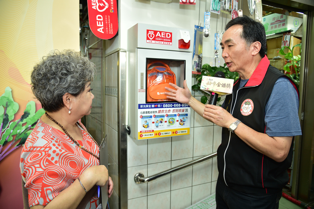 泰山市場總幹事李昌明向鳥來嬤介紹市場內的銀髮友善設施圖
